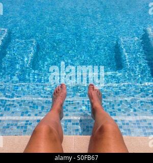 Füße und Beine auf einen Pool mit einer quadratischen Form von Schritten Stockfoto