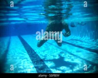 Schwimmer schwimmen Brust Unterwasserblick mit wässrigen Schatten, Reflexionen. Stockfoto