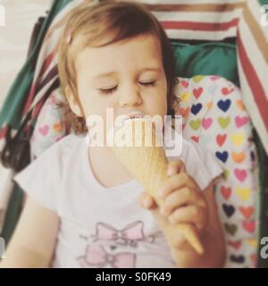 Babymädchen Eis essen Stockfoto