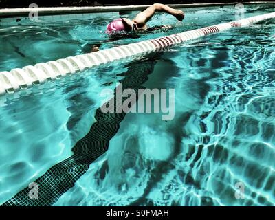 Blick vom angrenzenden Gasse, junge Frau, die Freestyle (Australien) Crawl in olympischer Größe außen 25 Meter-Becken schwimmen. San Francisco Bay Area, Kalifornien, USA. Stockfoto