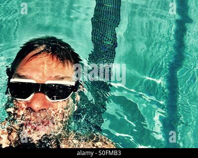 Der Schwimmer. Ansicht von oben über den Menschen Rücken im Außenpool schwimmen. Stockfoto