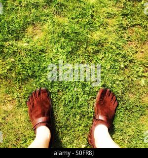 Mann Schuhe trägt Vibram FiveFingers stehen auf dem Rasen Stockfoto