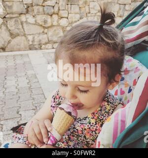 Babymädchen essen Eis im freien Stockfoto