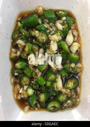 Draufsicht der gemischten geschnittenen grünen Chilischoten und Knoblauch in Sojasauce Stockfoto