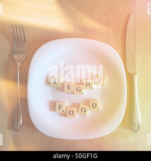 Platte mit dem Scrabble Wörter Licht Essen Stockfoto
