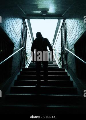 Mann geht die Treppe hinauf Stockfoto