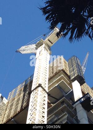 Auf der Suche nach einer Wipp Turmdrehkran neben einem Hochhaus gebaut werden Stockfoto