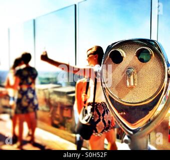 Touristen nehmen Selfie neben einer Münze betrieben Fernglas an Spitze der Felsen NYC Stockfoto