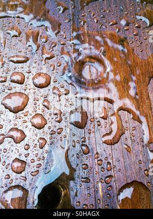 Regentropfen auf Holz Stockfoto