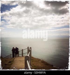 Zwei Menschen, die zu Fuß entlang der Küste Wanderweg in der Nähe von Mumbles, South Glamorgan, Wales Stockfoto