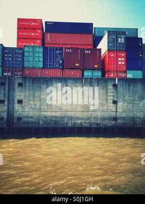 Container gestapelt im Hamburger Hafen, Deutschland vom Wasser aus gesehen Stockfoto