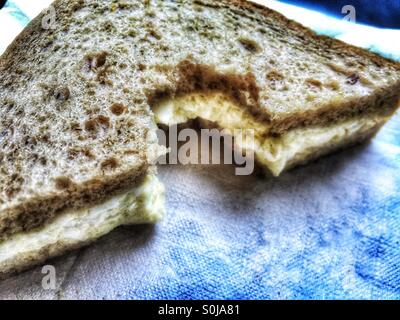 Mittags – einen großen Bissen genommen ein Sandwich Eiersalat auf Vollkornbrot Stockfoto