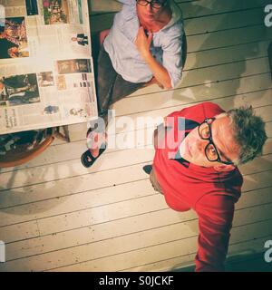 Mann und Frau in der Küche Broadsheet-Zeitung lesen Stockfoto