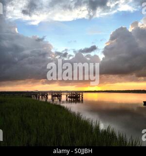 Er Sonnenuntergang in einem Gewitterhimmel über den Kiawah River auf Kiawah Island, South Carolina. Stockfoto