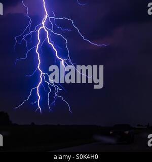 Stürmische Nacht. Ein mächtiger Blitz mit vielen verzweigten Streifen leuchtet einen düsteren Himmel auf. Konzepte: Ehrfurcht, Staunen, Macht, Natur. Stockfoto
