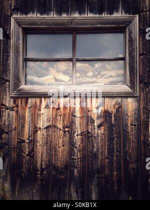 Fenster von einem hölzernen Schuppen gefüllt mit Brennholz Stockfoto