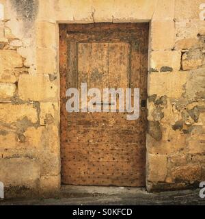 Ein altes besetzt hölzerne Tür an der Seite eines Hauses in St. Cyprien, Dordogne, Frankreich. Security-Konzept. Stockfoto