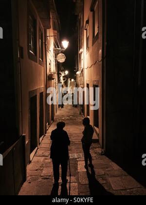 Zwei Damen in der Silhouette in der Nacht auf einer Straße von Porto Stockfoto