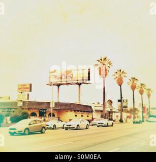 Sunset Boulevard-Verkehr in Los Angeles mit Palmen und Werbetafeln Stockfoto