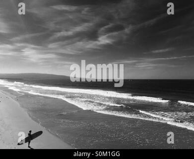 Surfer steht am Strand, Blick auf die Brandung. Manhattan Beach l, Kalifornien USA. Stockfoto