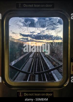 Blick auf den Sonnenuntergang über dem J Zugfenster u-Bahn in New York City. Stockfoto