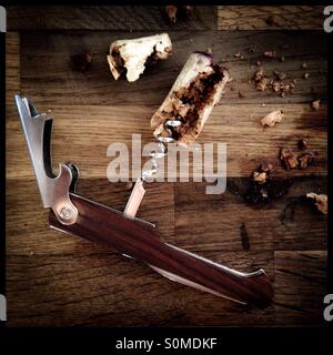 Weinkorken und ein "Freund des Kellners" auf einer Holzfläche gebrochen. Stockfoto