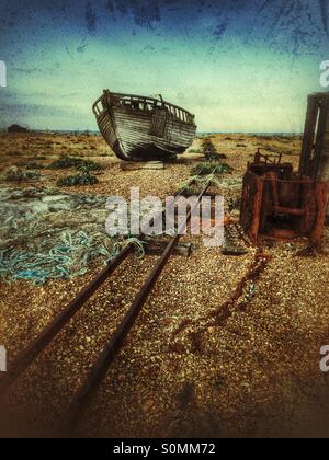 Verfallene Angelboot/Fischerboot und Rost Winde, neben der alten Bahntrasse, die zum Meer führt. Dungeness spucken, Kent, UK Stockfoto