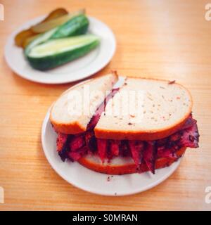 Pastrami auf Roggen-Sandwich mit einer Seitenlänge von Gurken, Katz Feinkost, Manhattan, New York City, Vereinigte Staaten von Amerika. Stockfoto