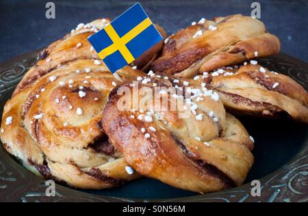 Auf dem rustikalen Silbertablett serviert traditionelle schwedische Zimtschnecken. Ein sehr beliebter Snack in ganz Skandinavien bekannt als Fika zusammen mit einer Tasse Kaffee. Stockfoto