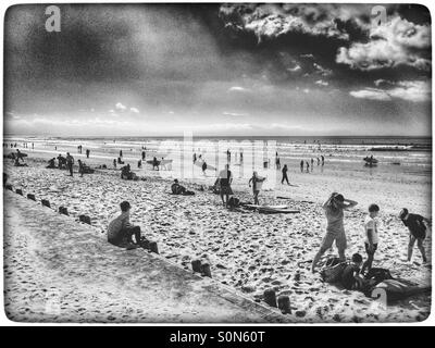 Schwarz / weiß Foto von Menschen genießen Tag am Strand von Muizenberg. Stockfoto