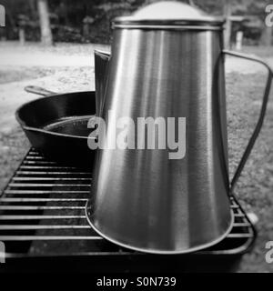 Kaffee Pott und Gusseisen Pfanne auf Camp-Kochfeld. Stockfoto