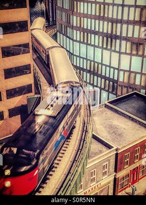 Eine Miniatur-Lokomotive läuft auf den Spuren von einer s-Bahn Modellierung Layout. Stockfoto