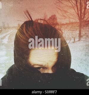 Eine Frau in einen Kampf gegen das kalte Wetter Schal gewickelt. Stockfoto