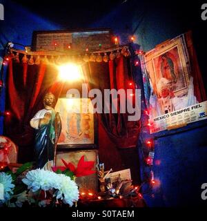 Ein Altar mit Bildern von Sain Jude Thaddeus und Our Lady of Guadalupe dekoriert mit elektrischem Licht und Rosen in Colonia Roma, Mexiko-Stadt, Mexiko Stockfoto