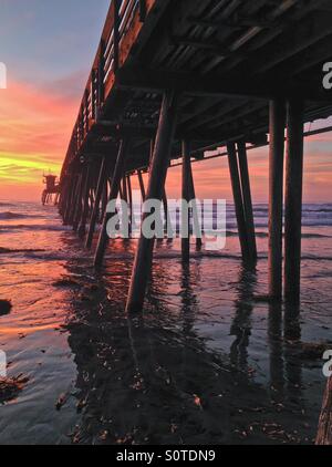 Imperial Beach Pier bei Sonnenuntergang mit Spiegelungen im Wasser, San Diego, Kalifornien Stockfoto