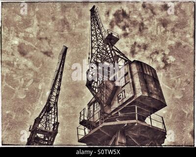 Zwei der Kraniche liegt am Rande von The Floating Harbour in Bristol, England. Ein Grunge-Effekt Bild im Laufe der Zeit und einer Zeit von vor langer Zeit zu illustrieren. Bildnachweis - © COLIN HOSKINS. Stockfoto