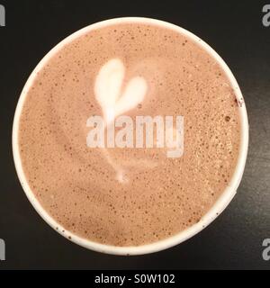Eine Tasse Latte/Kaffee mit Herz oben drauf. Stockfoto
