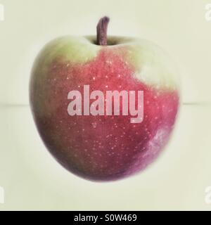 Ein roter & grüner Apfel auf einem Glastisch. Stockfoto