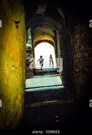 Zwei Silhouetten zu Fuß durch eine dunkle Gasse im Aufruf (Jüdisches Viertel), Girona, Katalonien Stockfoto