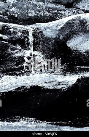 Ein kleiner Wasserfall stürzt über die Felsen von einem Bach im nördlichen Alabama, Juli 2012, in schwarz und weiß. Stockfoto