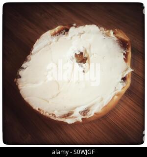 Bagel mit Frischkäse auf Holz Schneidebrett beschmiert Stockfoto