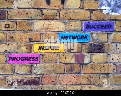 Street-Art im Bereich der Brick Lane, Shoreditch, East London, UK: farbige Ziegel mit inspirierende Konzepte Fortschritt inspirieren, vernetzen, erfolgreich zu sein Stockfoto