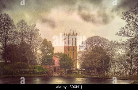 Landkirche infront von Teich, umgeben von Bäumen vor einem dramatischen Himmel. Gawsworth St. Jakobus. Cheshire. Stockfoto