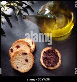 Home-geheilt schwarz gereift Spanisch Empeltre Oliven Tapenade mit Menage von Olivenöl extra vergine und Kekse. Stockfoto