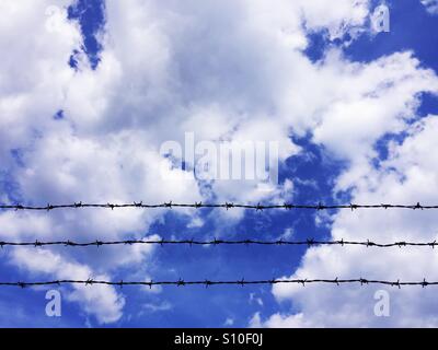 Stacheldraht am bewölkten Himmelshintergrund Stockfoto