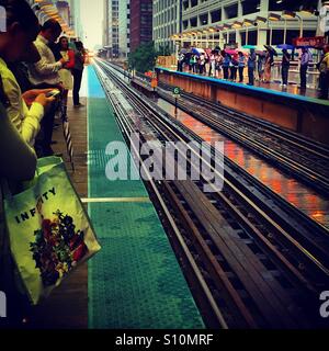 Pendler warten auf den Zug an einem regnerischen Nachmittag in Chicago Stockfoto