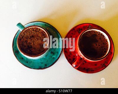 Zwei Tassen Kaffee: blau und rot Stockfoto