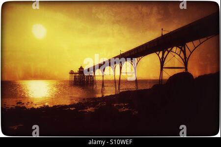 Ein kreativer Blick Clevedon Pier in Somerset, England, als die Sonne beginnt zu setzen. Clevedon Pier ist nur besuchbar Grade ein aufgeführten Pier in England. Bildnachweis - © COLIN HOSKINS. Stockfoto