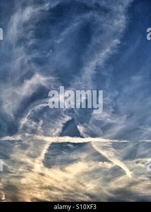 Wolken und Kondensstreifen am Abendhimmel Stockfoto