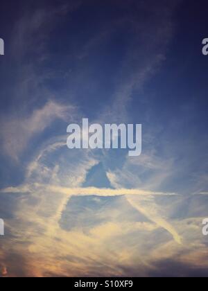 Wolken und Kondensstreifen am Abendhimmel Stockfoto